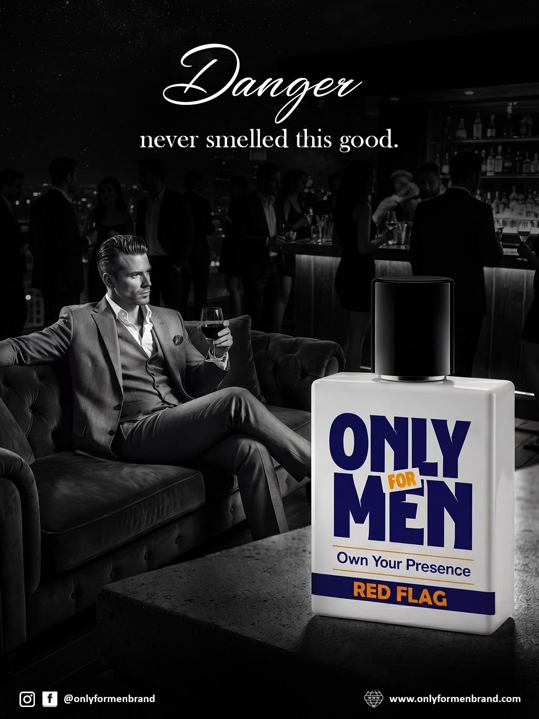 Man in a suit sitting on a couch with a bottle of 'Only for Men' cologne in a bar setting.